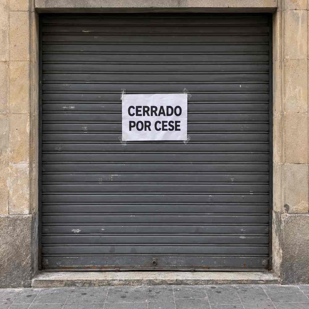 Persiana bajada con el cartel «Cerrado por cese»: cancelación de deudas de autónomos con el negocio cerrado en Barcelona
